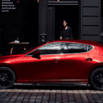 A red 2019 Mazda3 Hatchback on a cobblestone street