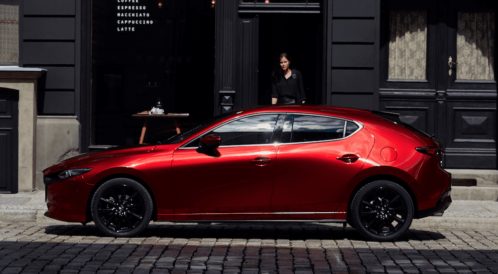 A red 2019 Mazda3 Hatchback on a cobblestone street