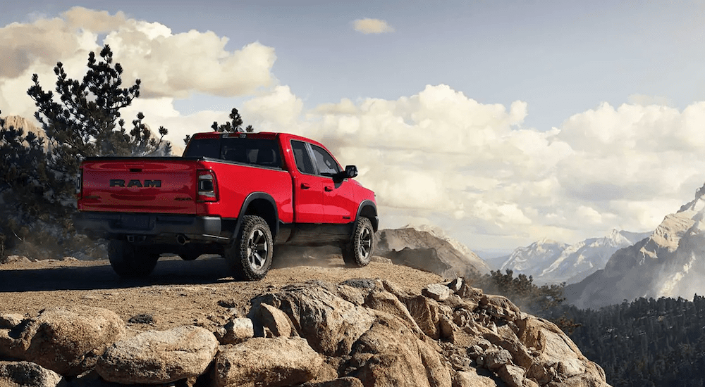 A red 2019 Ram 1500 on a majestic mountain against a cloudy sky
