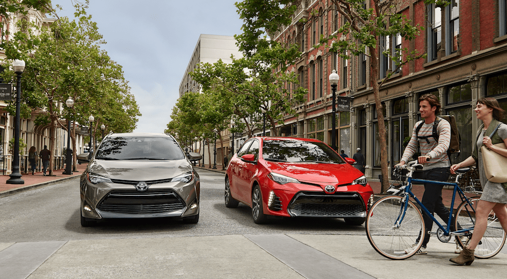 Two, red and gray, 2019 Toyota Corollas on a city street