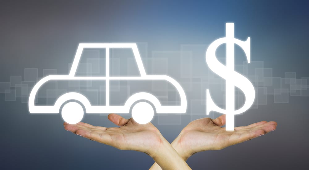 Car and dollar sign icons above crossed hands against a gray background. Finding the value of used cars with a vehicle history report