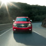A red 2019 Chevy Tahoe whips around a winding road