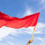 A symbolic red flag that you might be at he wrong jeep dealership against a blue and cloudy sky