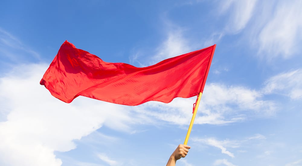 A symbolic red flag that you might be at he wrong jeep dealership against a blue and cloudy sky