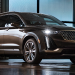 The future 2020 Cadillac XT6 is shown in a grey-brown color at night.