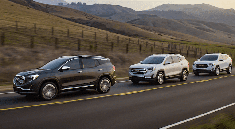 A group of GMC Terrains travel a hilly road