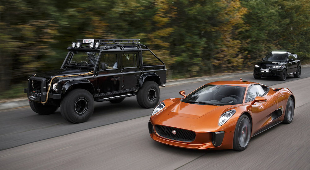 A black offroading SUV, a black sporty SUV and an orange super car from JLR Special Vehicle Operations are pictured driving.
