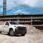 A white Silverado drives through a construction site after winning the Chevy Silverado vs 2019 Nissan Titan