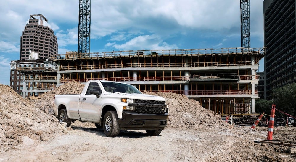 A white Silverado drives through a construction site after winning the Chevy Silverado vs 2019 Nissan Titan