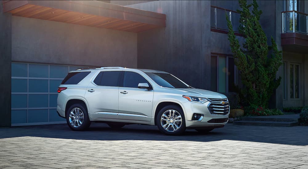 A white 2019 Chevy Traverse is parked outside a modern house.