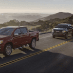 A group of GMC Canyons driving on a scenic road