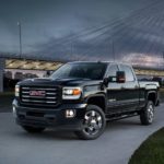 A black 2019 GMC All terrain edition is parked in front of a bridge