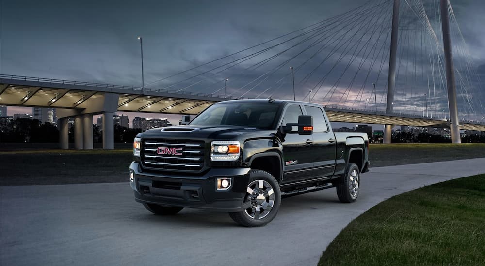 A black 2019 GMC All terrain edition is parked in front of a bridge