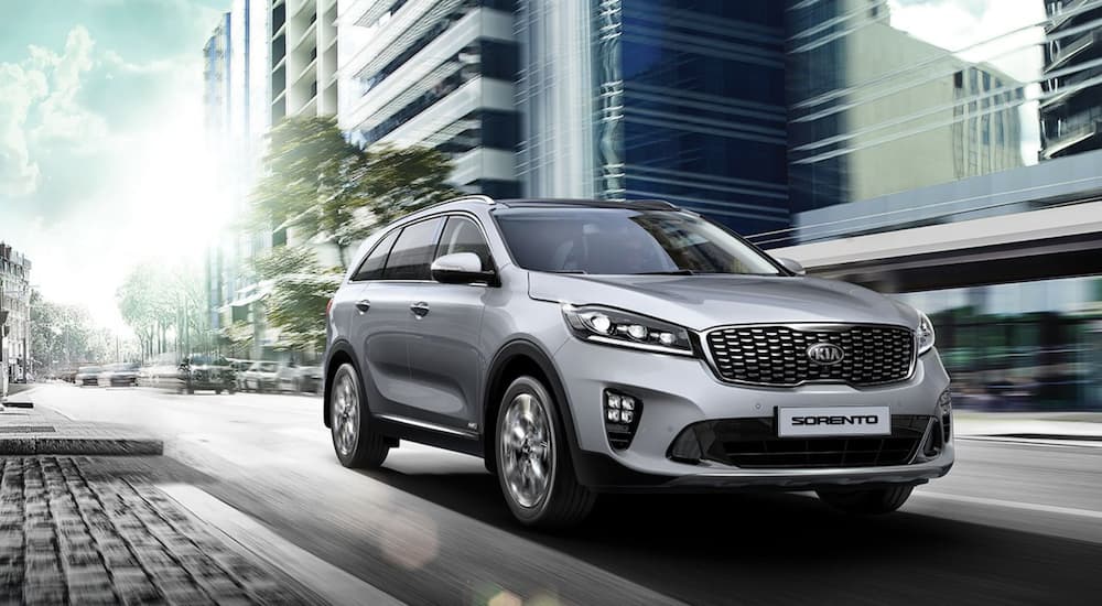 A silver 2019 KIA Sorento is driving through the city.