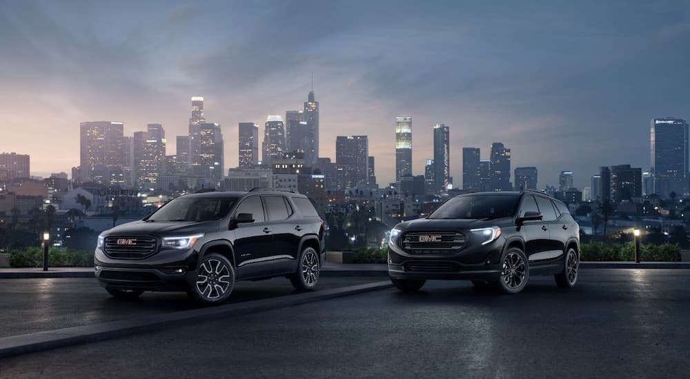 The Black Editions of the 2019 Acadia and Terrain are part of the GMC SUVs lineup. They are shown with a city skyline in the background.
