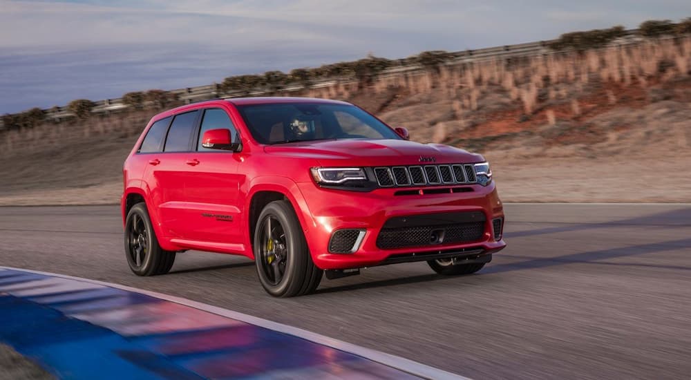 A red 2018 Jeep Grand Cherokee Trackhawk is shown on a track.