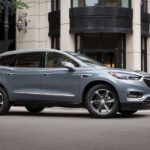 A gray 2019 Buick Enclave drives through an intersection.