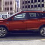 A red 2019 Ford Escape is parked on top of a parking garage in the city.