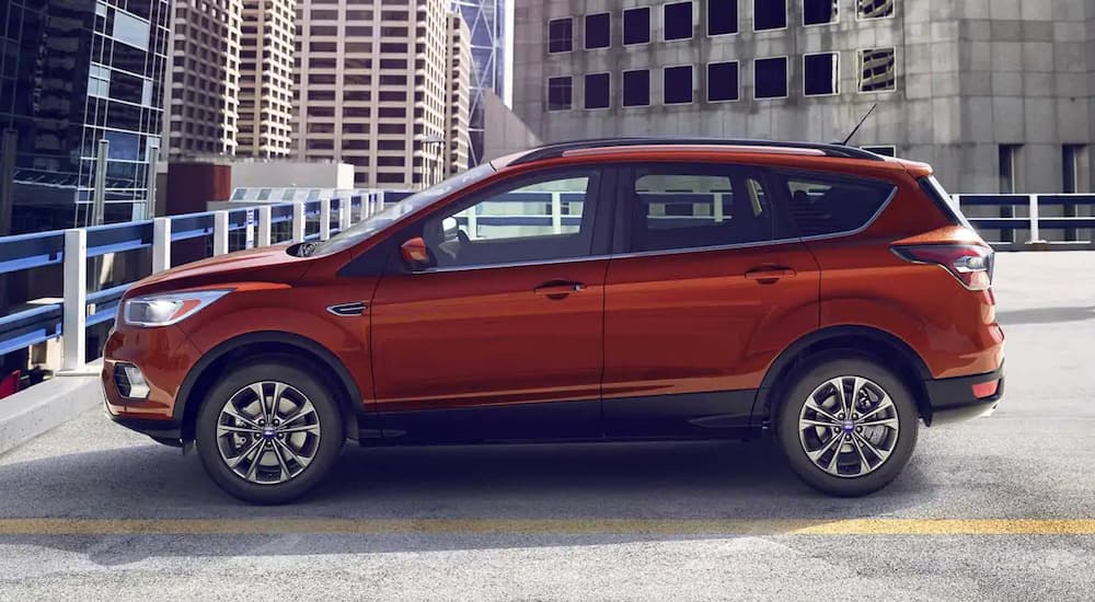 A red 2019 Ford Escape is parked on top of a parking garage in the city.