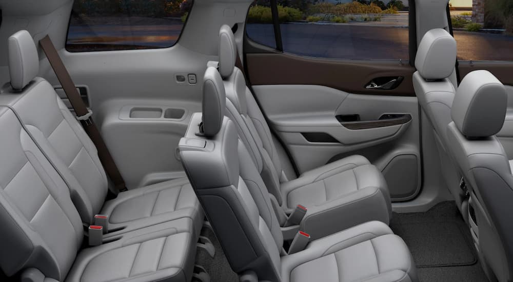 The grey interior of the 2019 GMC Acadia is showing the two back rows of seating. Check out interior when comparing the 2019 GMC Acadia vs 2019 Nissan Pathfinder.