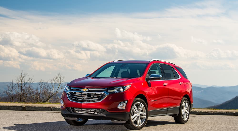 The 2019 Chevy Equinox is parked in a parking lot with a cloudy blue sky behind it.