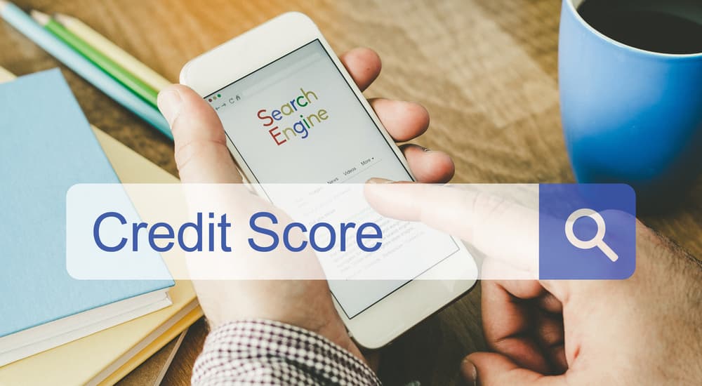 A phone is showing a search for 'credit score'.