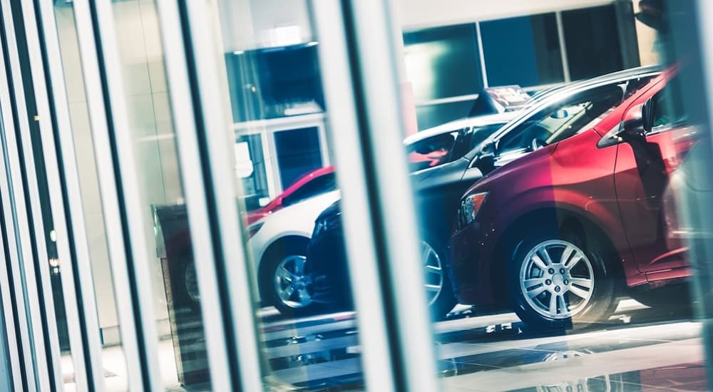 Models inside a used car dealer can be seen through the building's glass windows.