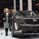 Deb Wahl marketing CEO for Cadillac in front of an Escalade at a car show