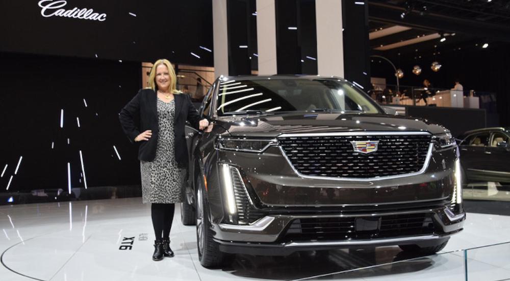 Deb Wahl marketing CEO for Cadillac in front of an Escalade at a car show