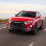A red 2019 Chevy Blazer is driving past a bay.