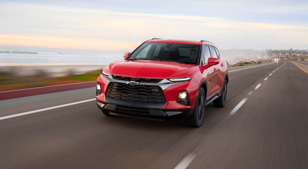 A red 2019 Chevy Blazer is driving past a bay.