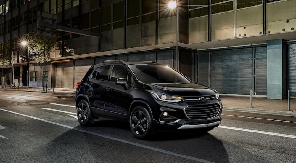 The 2019 Chevy Trax Midnight Edition is driving through a city at night.