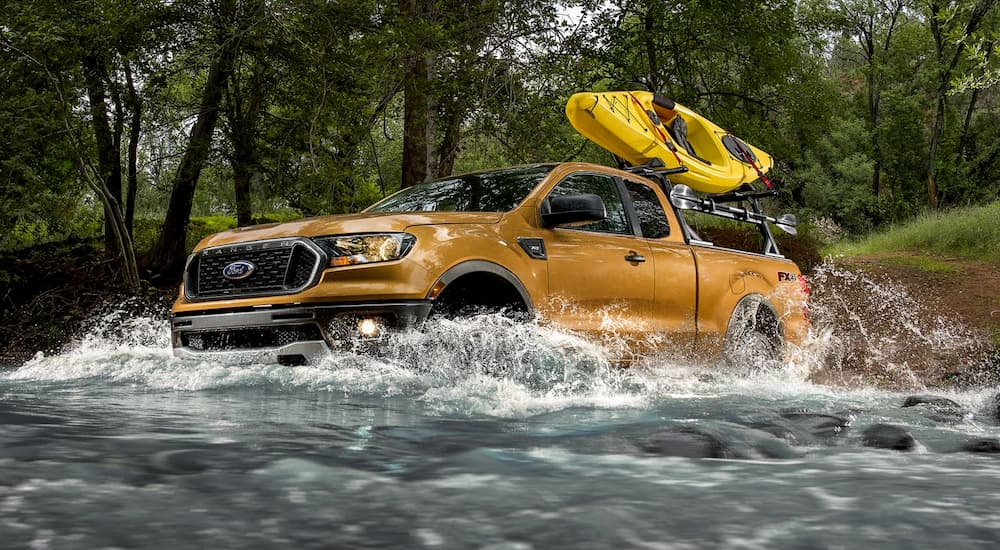 A gold 2019 Ford Ranger is crossing a river. Check out the solid comparison between the 2019 Ford Ranger vs 2020 Jeep Gladiator.