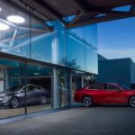 A red 2019 Chevy Malibu parked in front of a glass window.