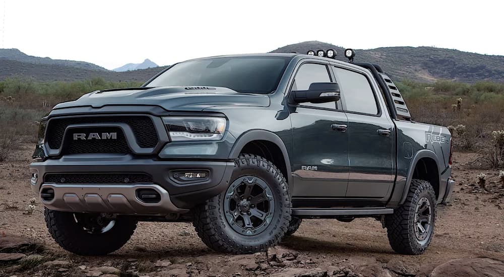 The dark colored Ram Rebel Sema build, one of the lift trucks concepts, is parked in front of mountains.