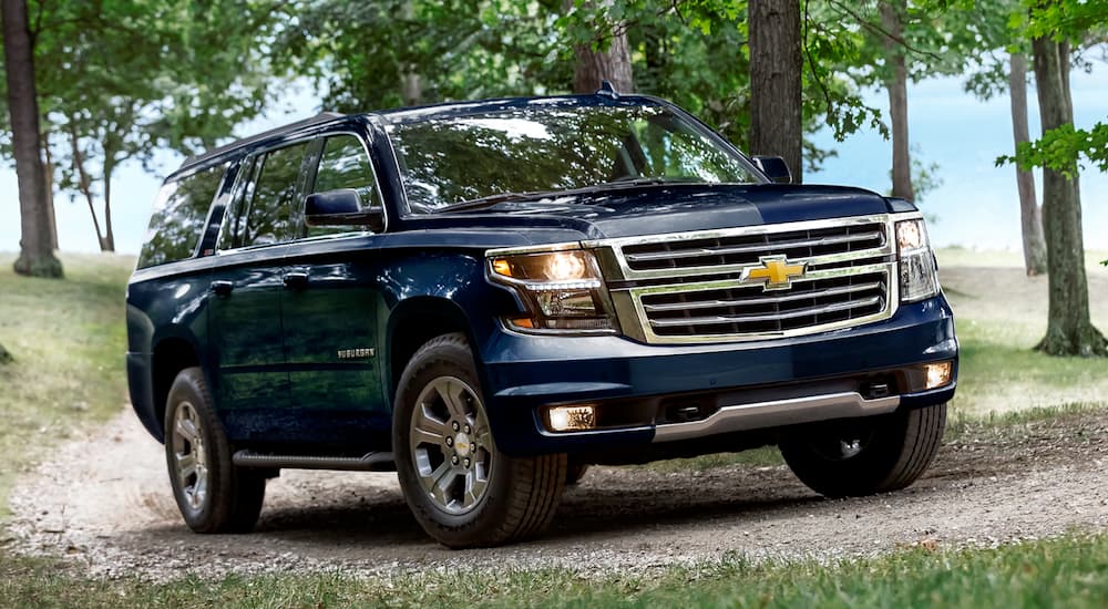 A blue 2019 Chevy Suburban is on a gravel road.