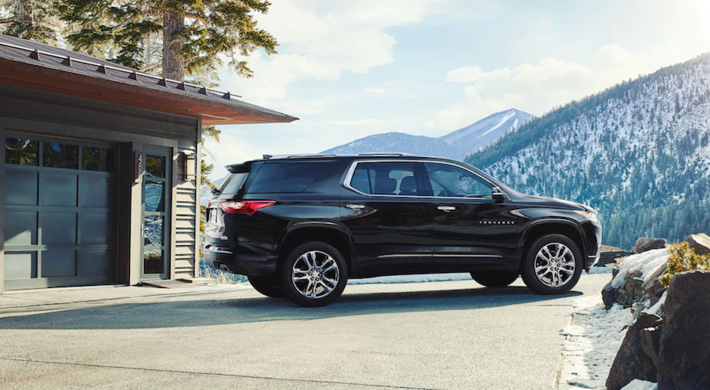 A black 2019 Chevy Traverse is parked at a mountain house.