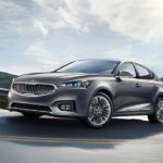 A grey 2019 Kia Cadenza is driving on the highway after leaving a car dealership near me.