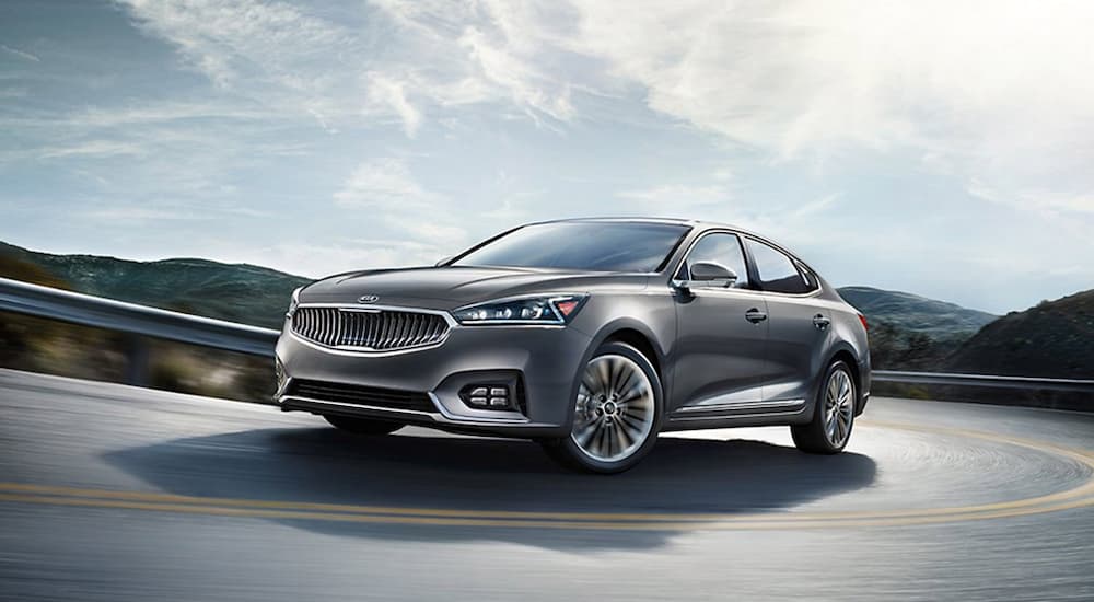 A grey 2019 Kia Cadenza is driving on the highway after leaving a car dealership near me.