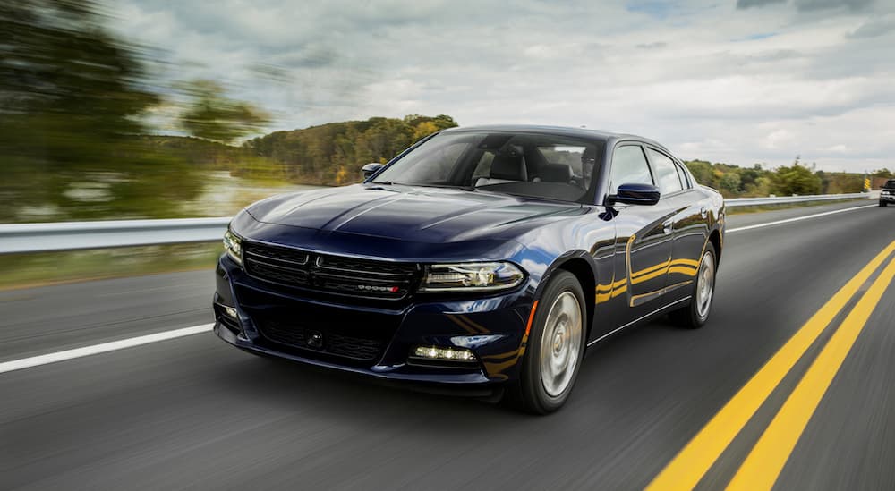 A blue 2017 Dodge Charger, popular among used cars near me, is on a highway.