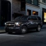 A black 2020 Chevy Tahoe is on a city street at night.
