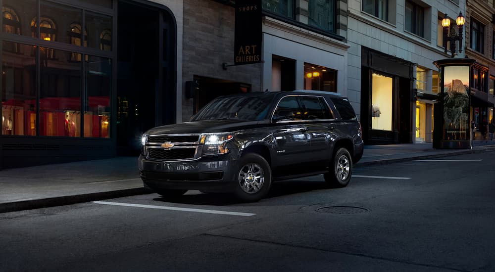 A black 2020 Chevy Tahoe is on a city street at night.