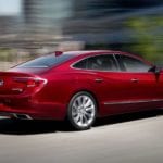 A red 2019 Buick LaCrosse is driving with a blurred background.