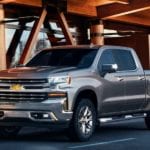 A grey 2020 Chevy Silverado is parked outside of a wood and glass building at a Chevy dealer.