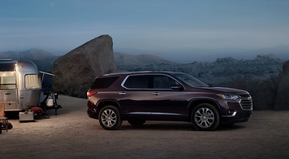A burgundy 2020 Chevy Traverse is parked at a camp site at dusk.
