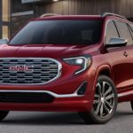 A red 2019 GMC Terrain is parked in front of a house.
