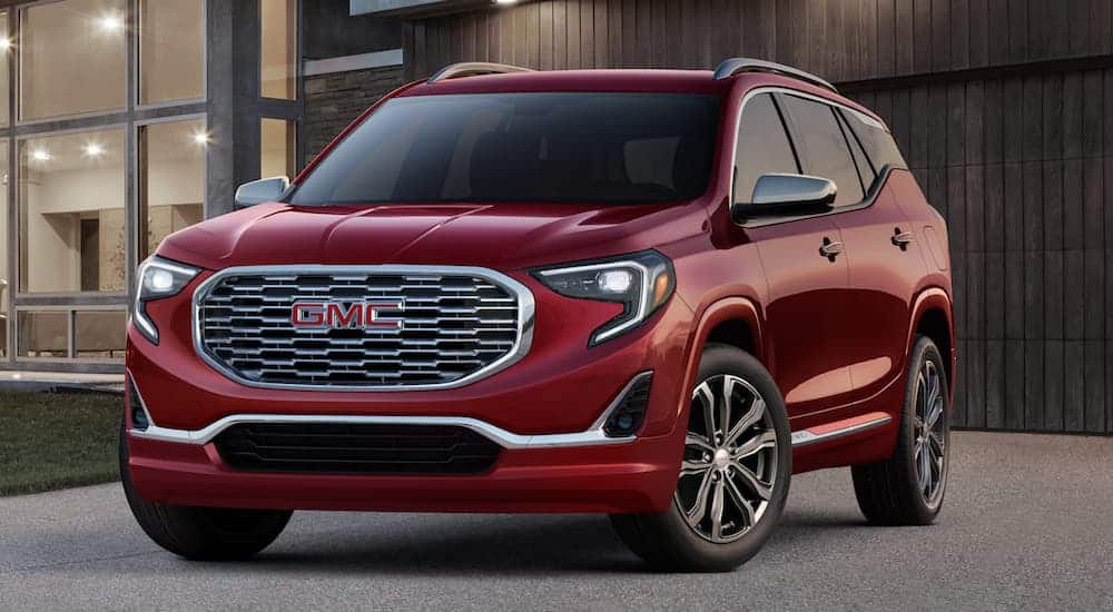 A red 2019 GMC Terrain is parked in front of a house.