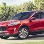 A red 2020 Ford Escape is parked in a driveway on a sunny day.