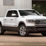 A white 2020 Ram 1500 is parked in front of a metal walled building.