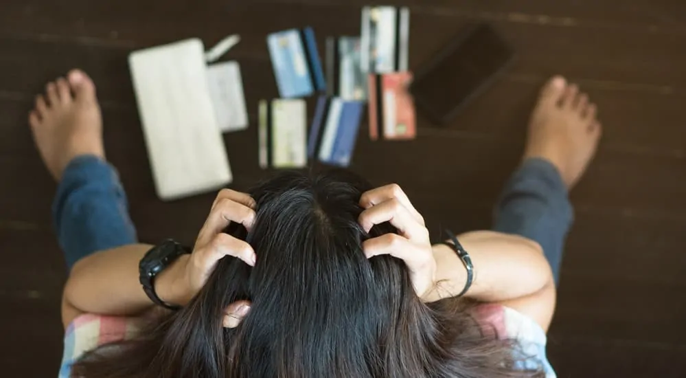 A woman is stressed out while looking over her credit cards.